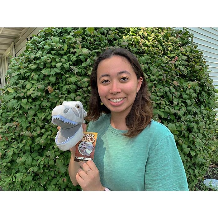 Woman holding Roaring T. rex plush
